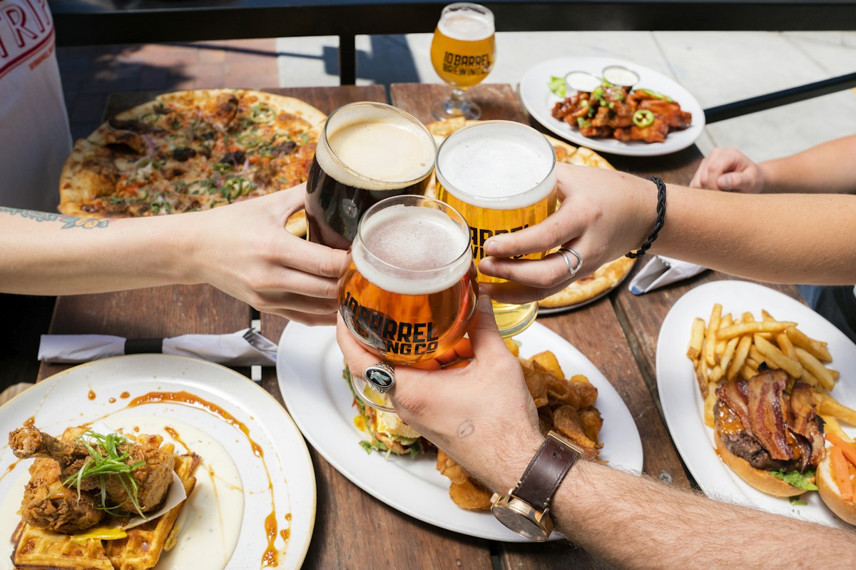 Pessoas brindando com copos de chopp