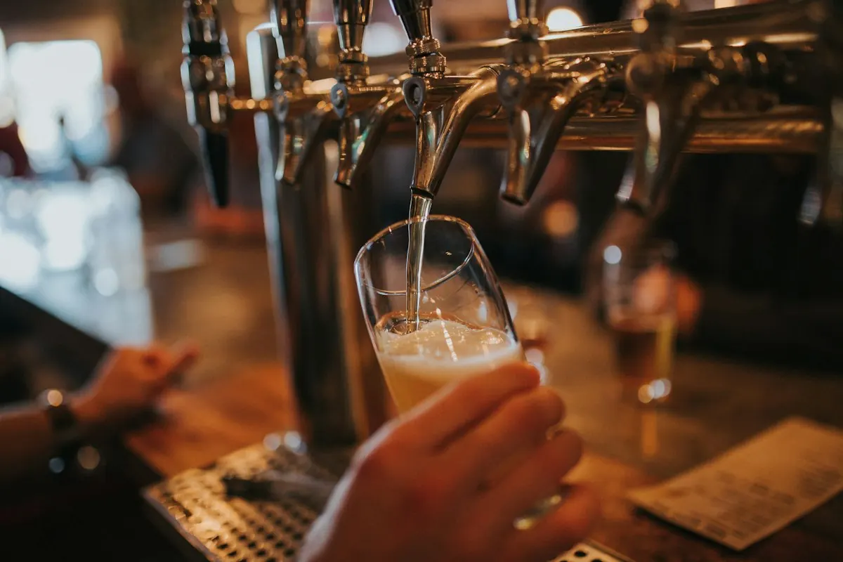Chopp sendo tirado na torneira da chopeira